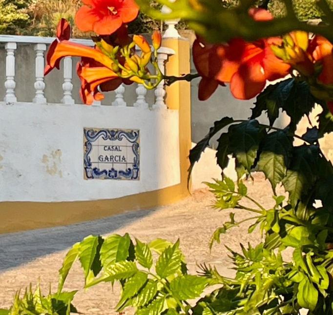 una casa con una valla y flores delante de ella en BBmontejunto en Cadaval