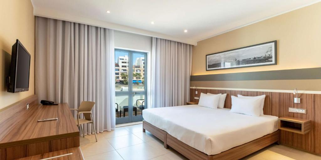 a hotel room with a bed and a window at DoubleTree by Hilton Malta in St Paul's Bay