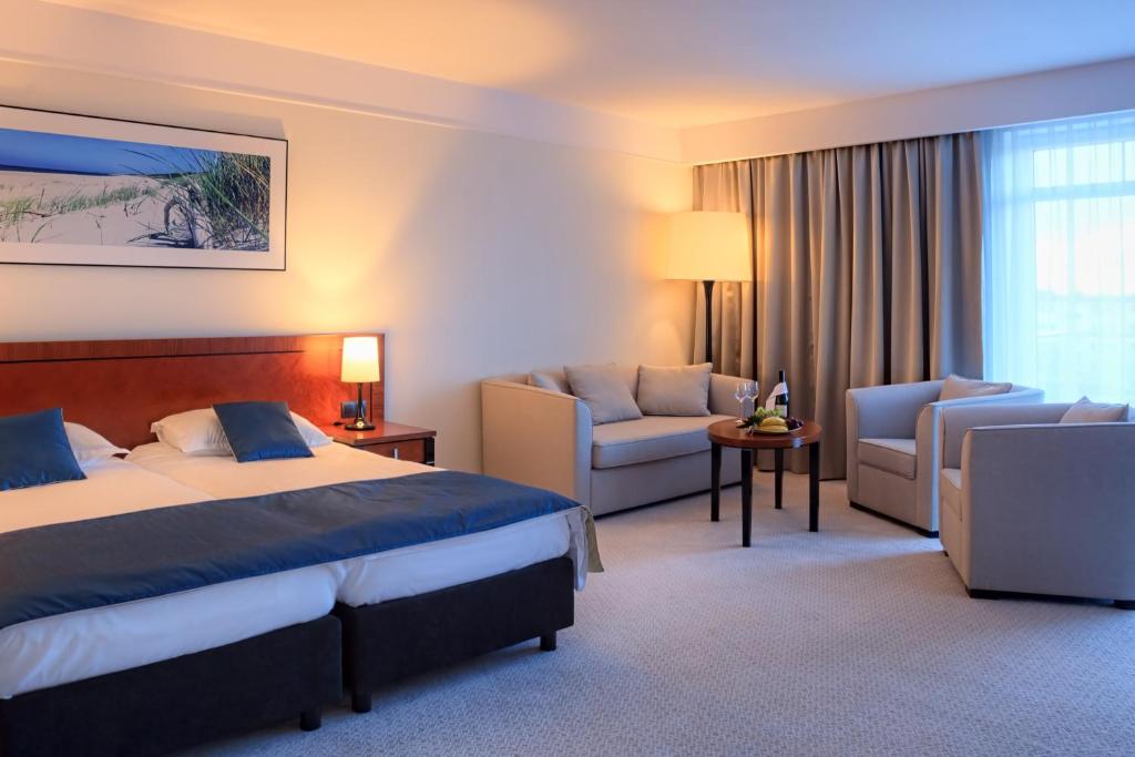 a hotel room with a bed and a couch at Grand Lubicz Uzdrowisko Ustka in Ustka