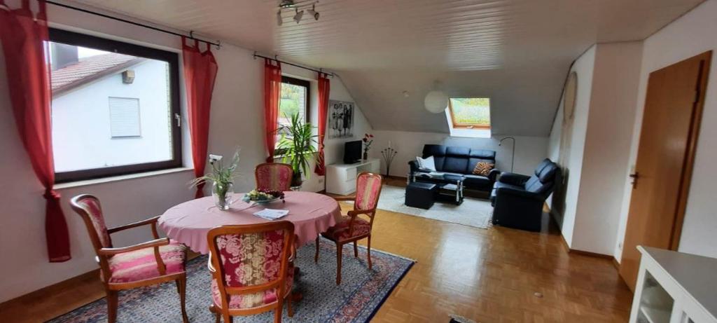 sala de estar con mesa, sillas y sofá en Sterngässle en Deggingen