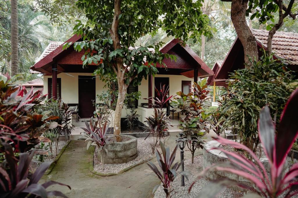 ein Haus im Dschungel mit Bäumen und Pflanzen in der Unterkunft SAVITHRI INN Cottages in Varkala