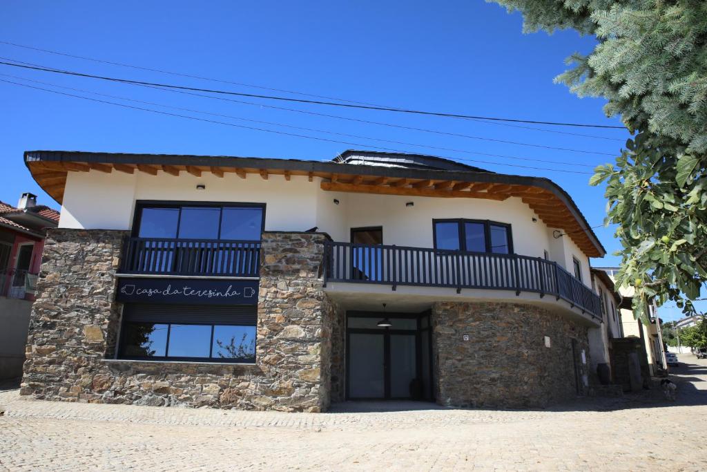 une maison en pierre avec un balcon au-dessus dans l'établissement Casa da Teresinha, à Bragance