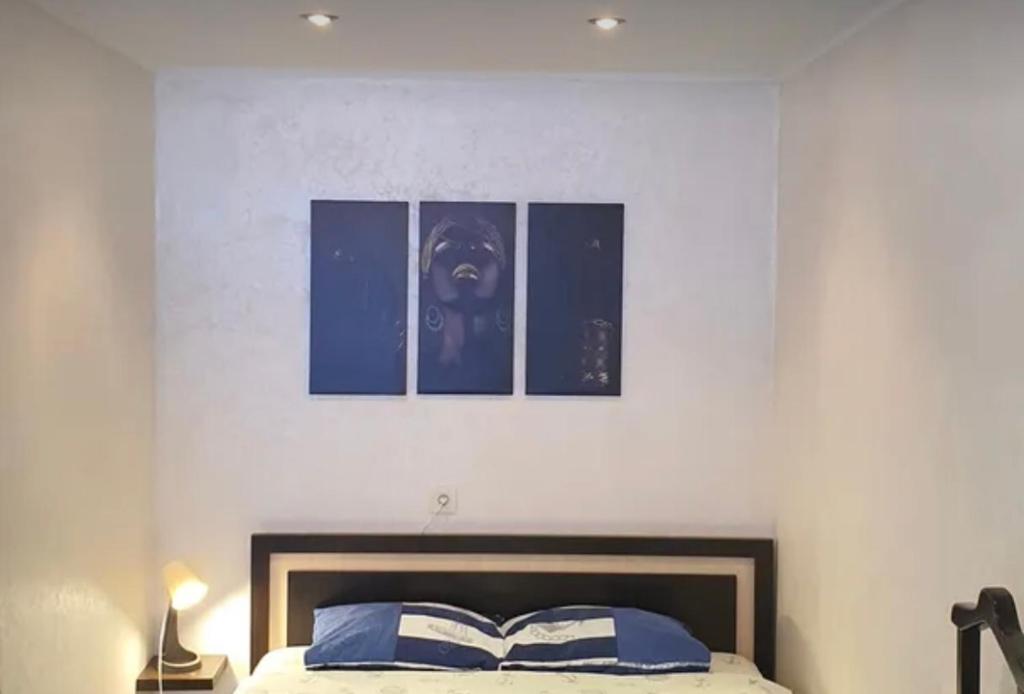 um quarto com uma cama com três fotografias na parede em VIP apart 734 em Tbilisi