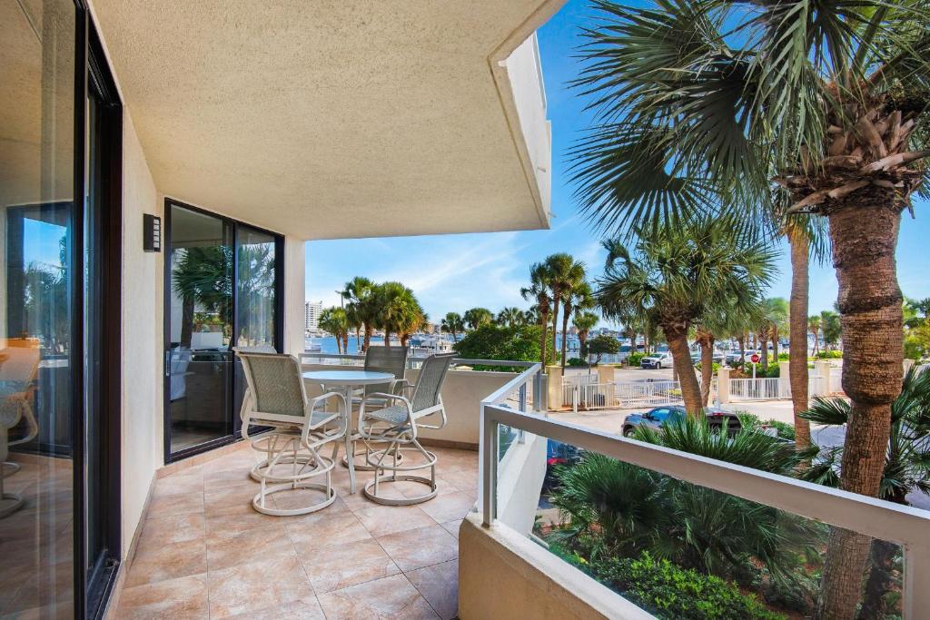 a balcony with a table and chairs and palm trees at East Pass 102 in Destin