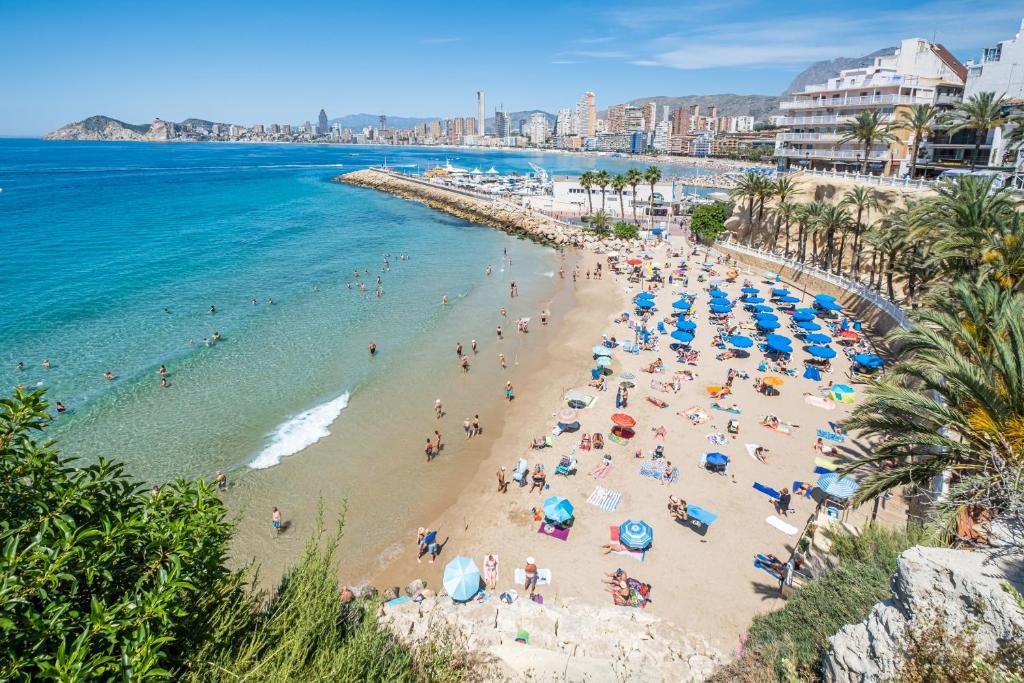 a beach with people and umbrellas and the ocean at Benidorm Old Town 48 Apartment 2-C in Benidorm