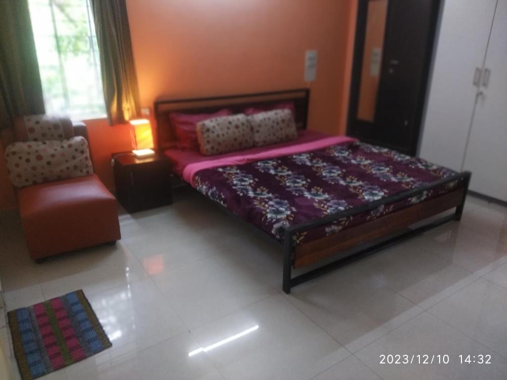 a bedroom with a large bed and a chair at Royale Seaward Supreme in Chennai