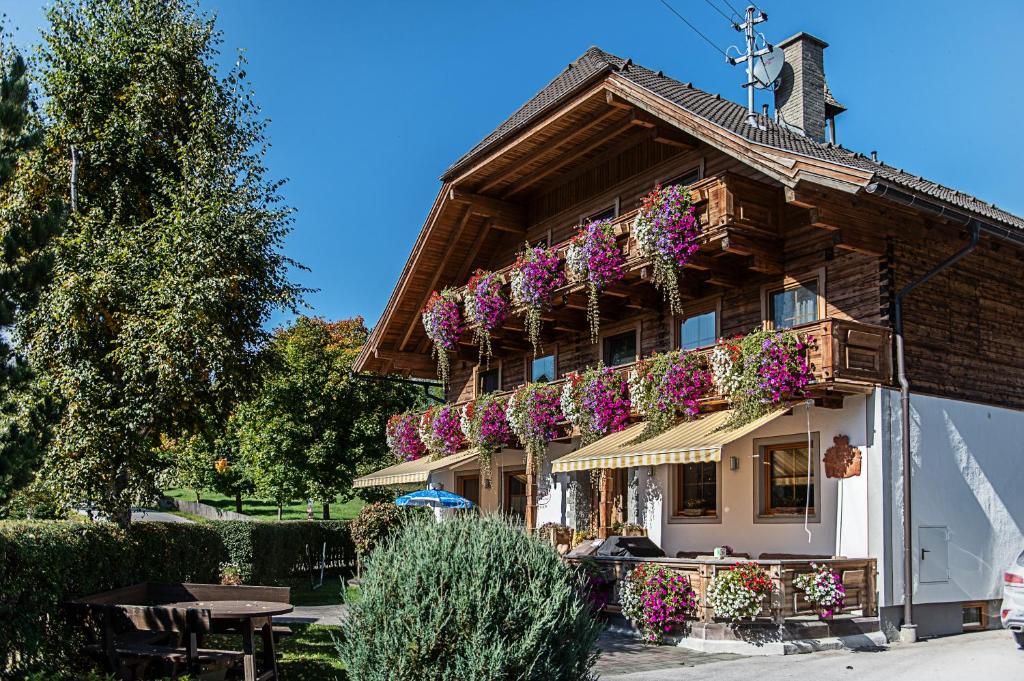 a building with flowers on the side of it at Pension Bacherhof in Mariapfarr