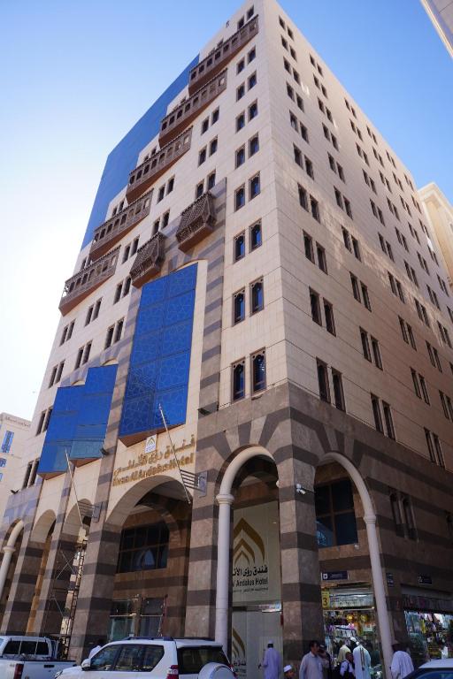 un grand bâtiment avec des fenêtres bleues dans une ville dans l'établissement Roaa Al Andalus Hotel فندق رؤى الاندلس, à Médine