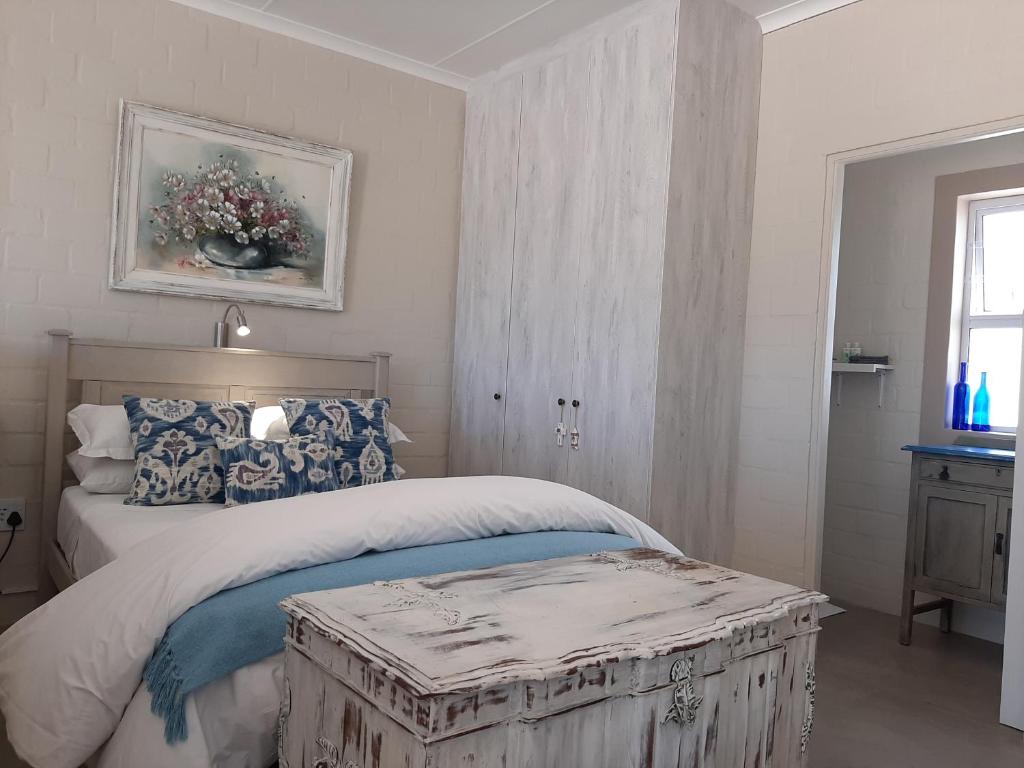 a bedroom with a large bed with a wooden trunk at WestBed in Langebaan