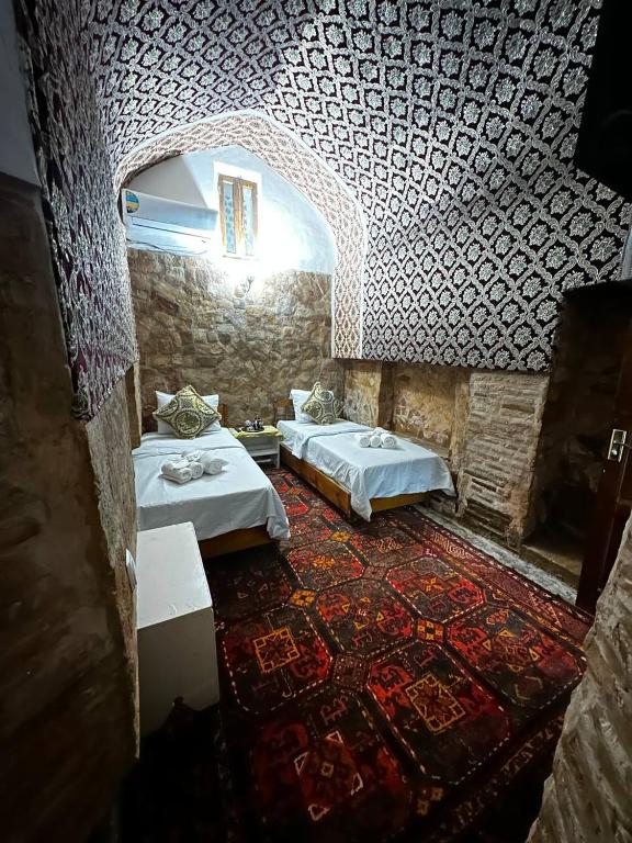 Pokój z 2 łóżkami i wzorzystym sufitem w obiekcie Mekhtar ambar w mieście Buchara