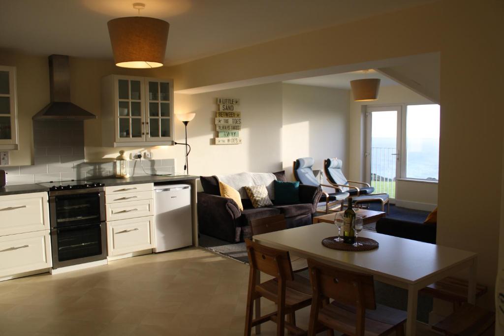 eine Küche und ein Wohnzimmer mit einem Sofa und einem Tisch in der Unterkunft Dunmore East Holiday and Golf Resort Apartments in Dunmore East
