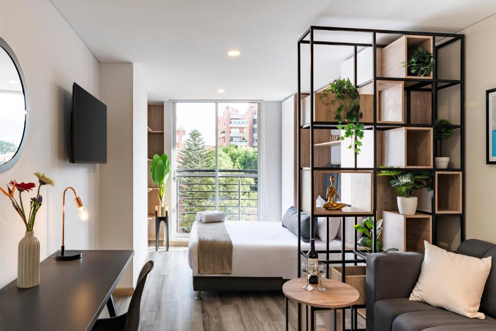a living room with a bed and a desk at Cabrera 85 Apartments in Bogotá