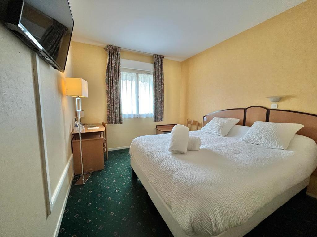 Postel nebo postele na pokoji v ubytování Logis Hôtel Sully le Château