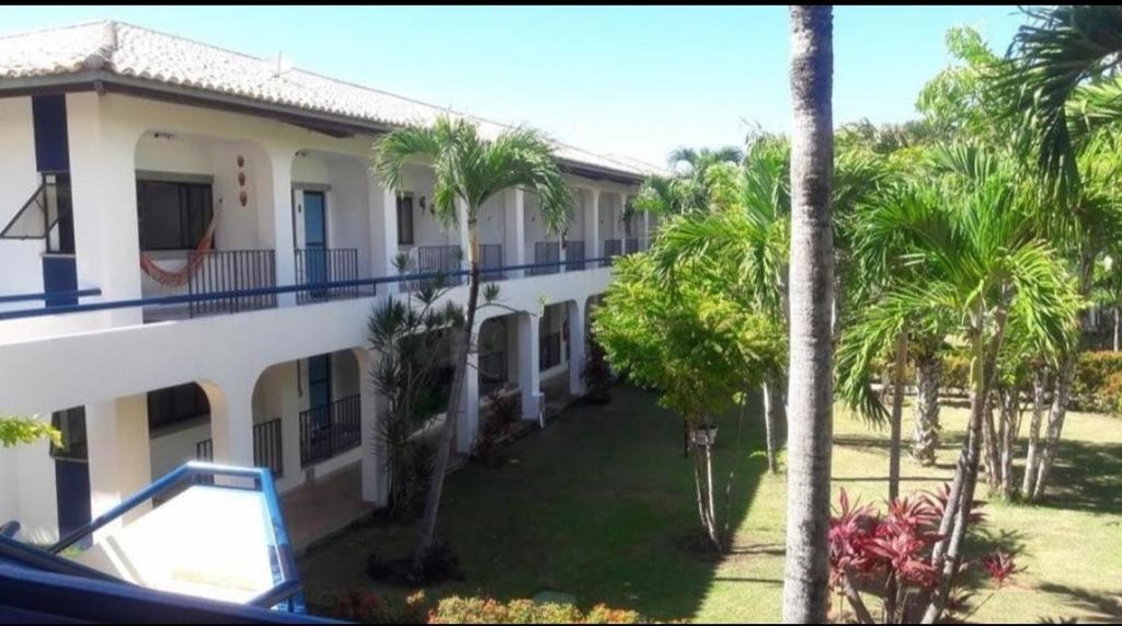 uitzicht op een gebouw met palmbomen bij Guarajuba Summer Flat in Guarajuba