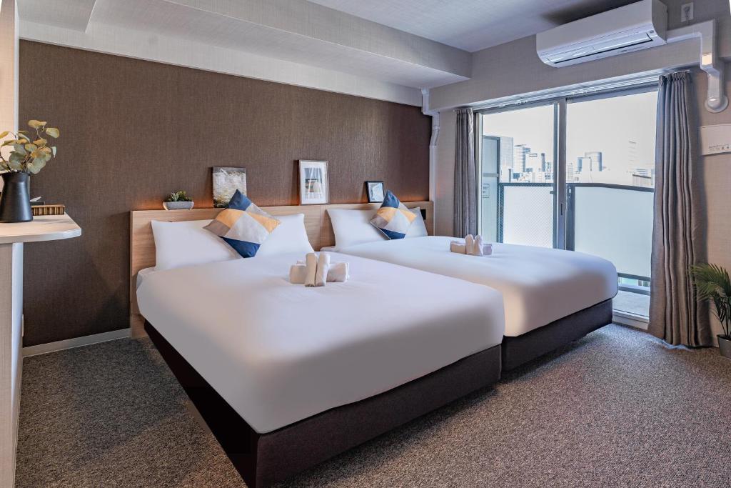 Postel nebo postele na pokoji v ubytování Apartment Hotel 11 Shinsaibashi 3
