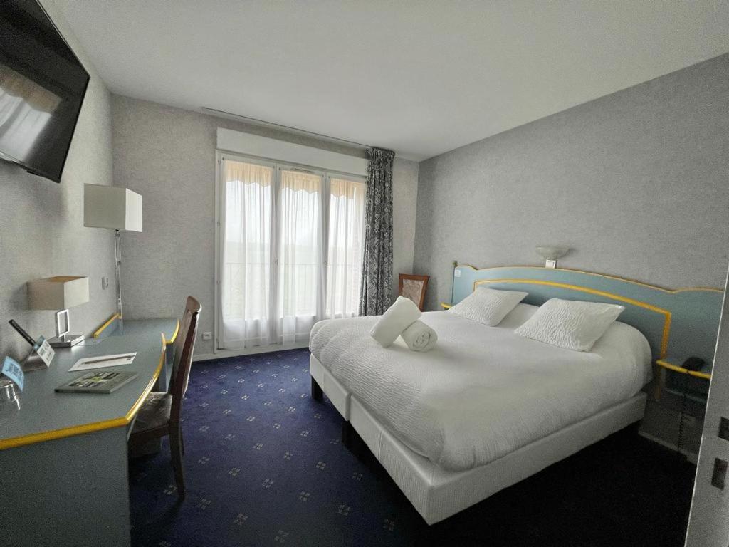 Postel nebo postele na pokoji v ubytování Logis Hôtel Sully le Château