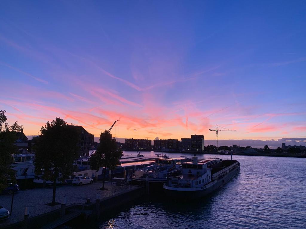 ドルドレヒトにあるApartment Lange Geldersekade 3, Dordrecht 80 m2の夕暮れ時に川に停泊