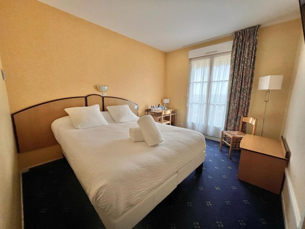 Postel nebo postele na pokoji v ubytování Logis Hôtel Sully le Château