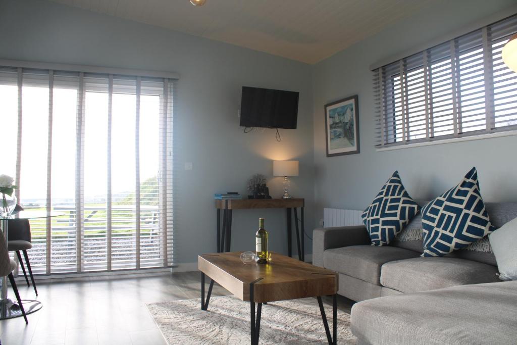 ein Wohnzimmer mit einem Sofa und einem Tisch in der Unterkunft Dunmore East Ocean View Suite in Dunmore East