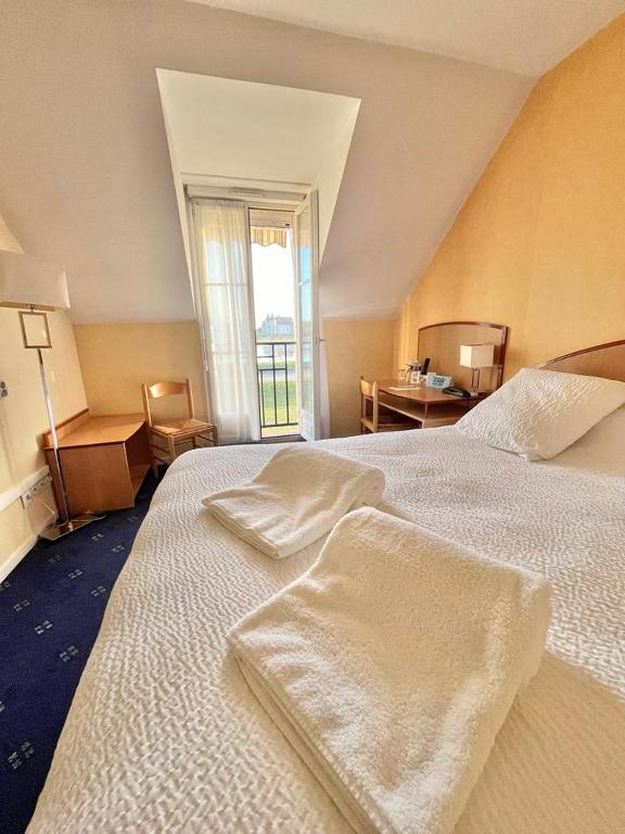 Postel nebo postele na pokoji v ubytování Logis Hôtel Sully le Château