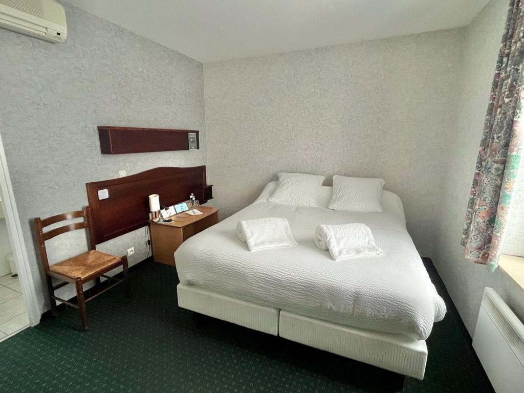 Postel nebo postele na pokoji v ubytování Logis Hôtel Sully le Château
