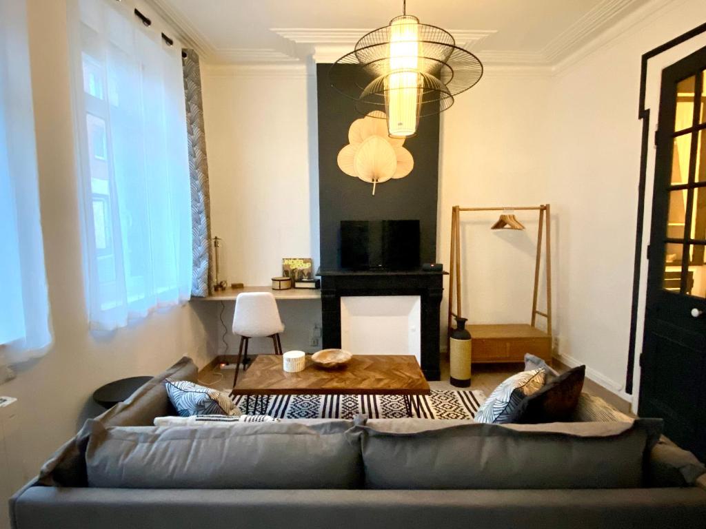 un salon avec un canapé et une table dans l'établissement L'Art appart' - T2 - Lit King Size - Proche centre, à Amiens