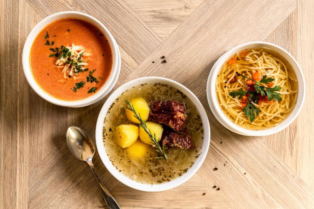 a table with two bowls of soup and a bowl of food at Willa Amicus in Zakopane