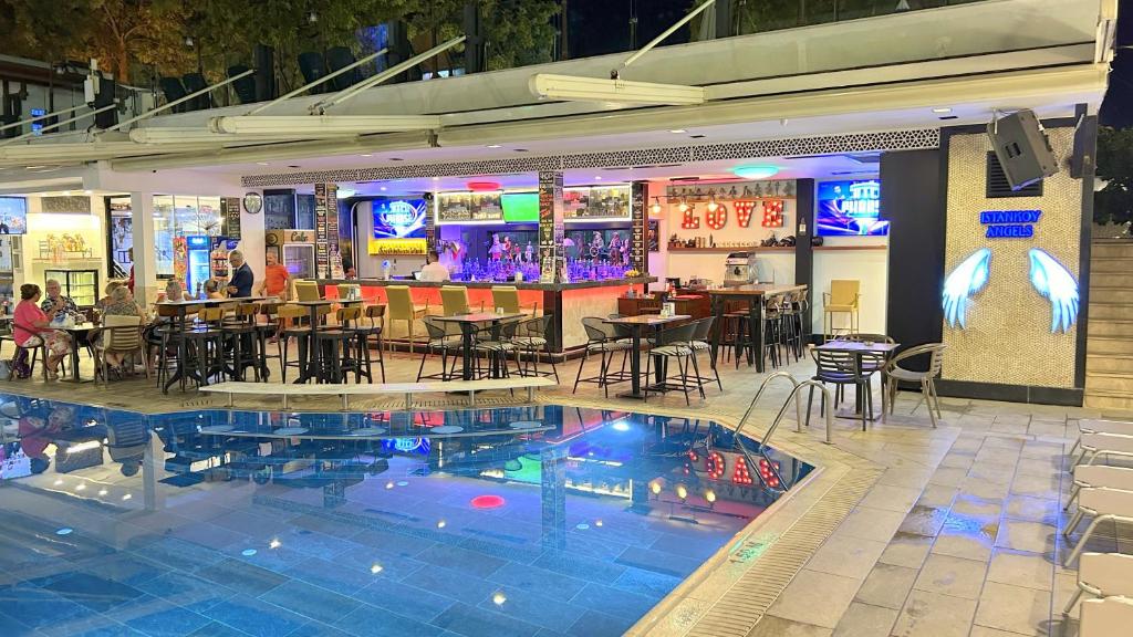 a restaurant with a bar and a swimming pool at Istankoy Hotel in Bodrum City