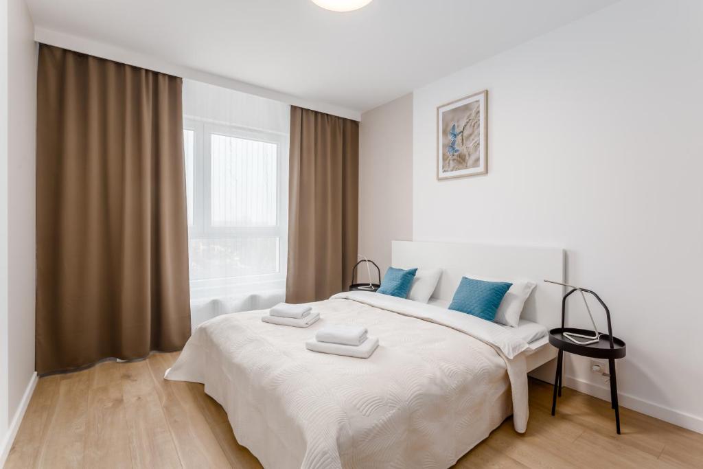 a white bedroom with a large bed with blue pillows at Warsaw City Family Premium in Warsaw