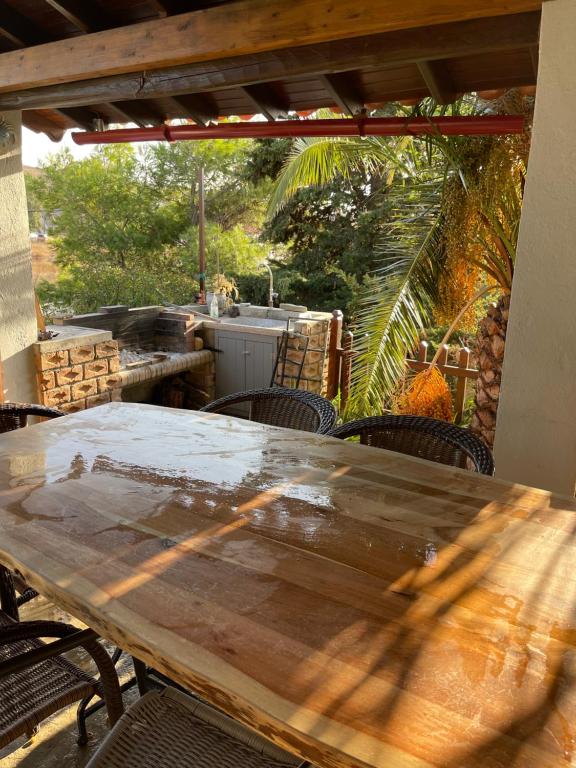 einen Holztisch und Stühle auf einer Terrasse in der Unterkunft Kalyva Cottage in Mirina
