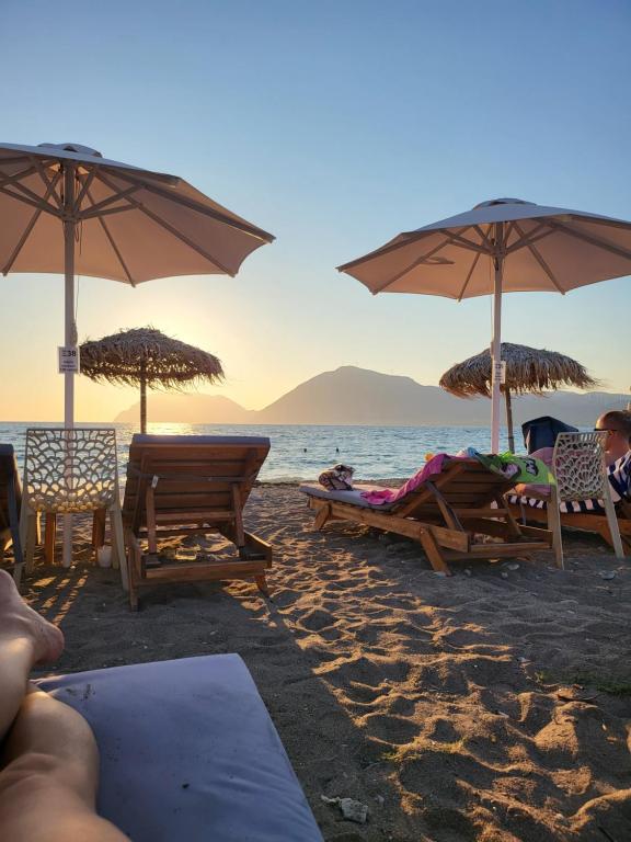 a group of people sitting on the beach under umbrellas at Βίλα Σια in Rio