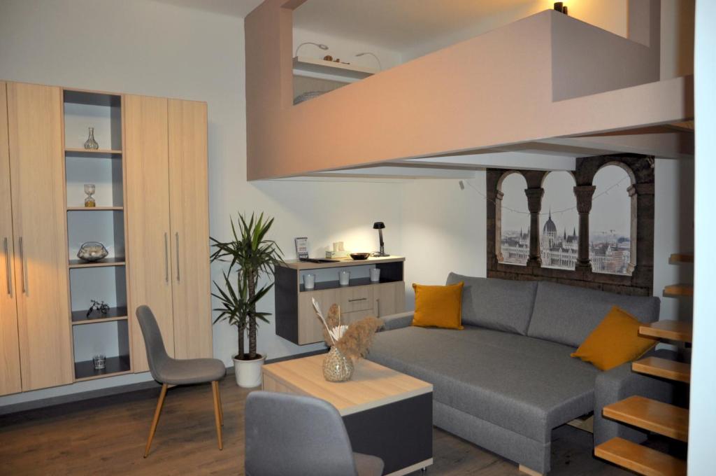 sala de estar con sofá gris y almohadas amarillas en Angel's Apartman en Budapest