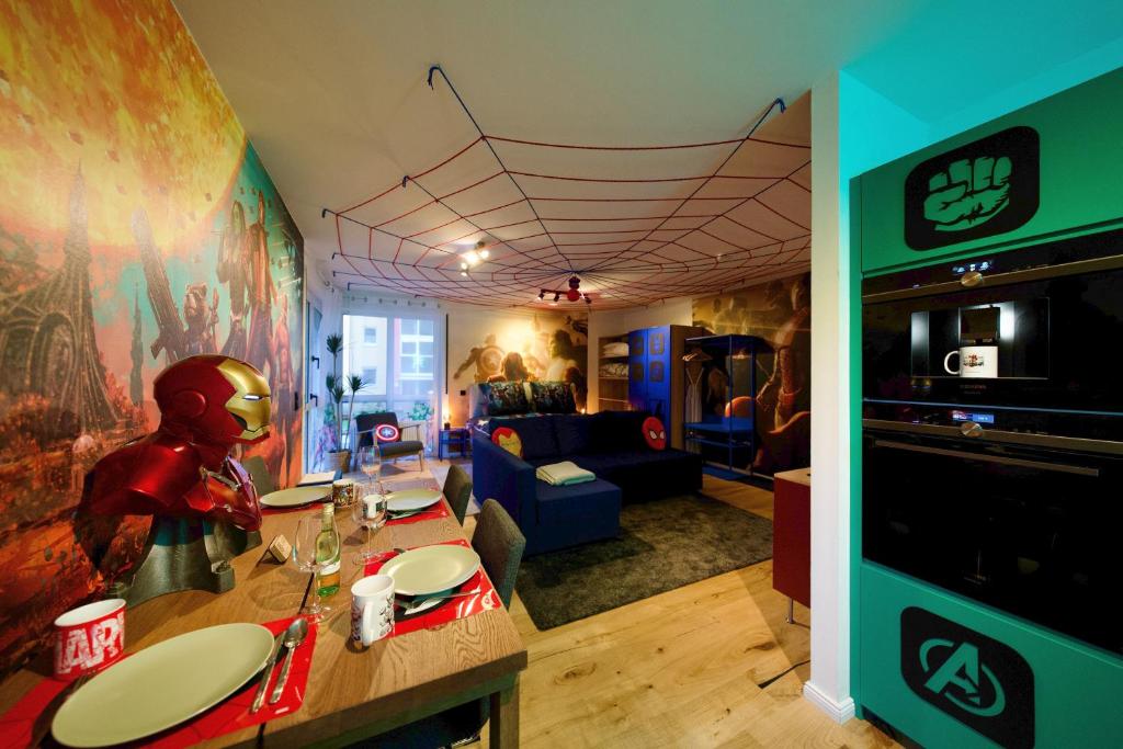 a living room with a table and a room with a spider man painting at EDLER WOHNRAUM Disney Marvel Studio mit Boxspringbett, Netflix, Einbaukaffeevollautomat, Terrasse & Lift in Chemnitz