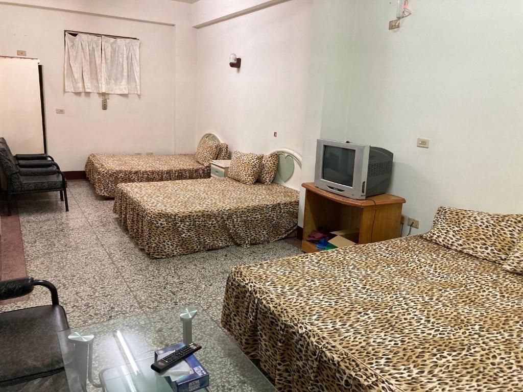 ein Hotelzimmer mit 3 Betten und einem TV in der Unterkunft 東海旅社 有匯款才會留房喔 in Shuili