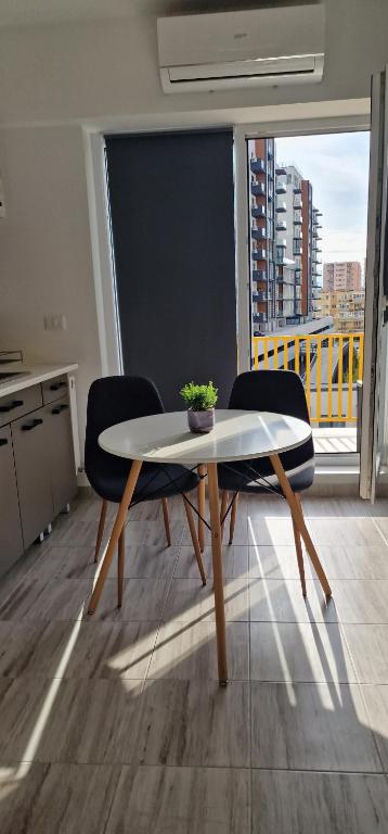 een tafel en 2 stoelen in een kamer met een raam bij Titan 4 Residance in Boekarest