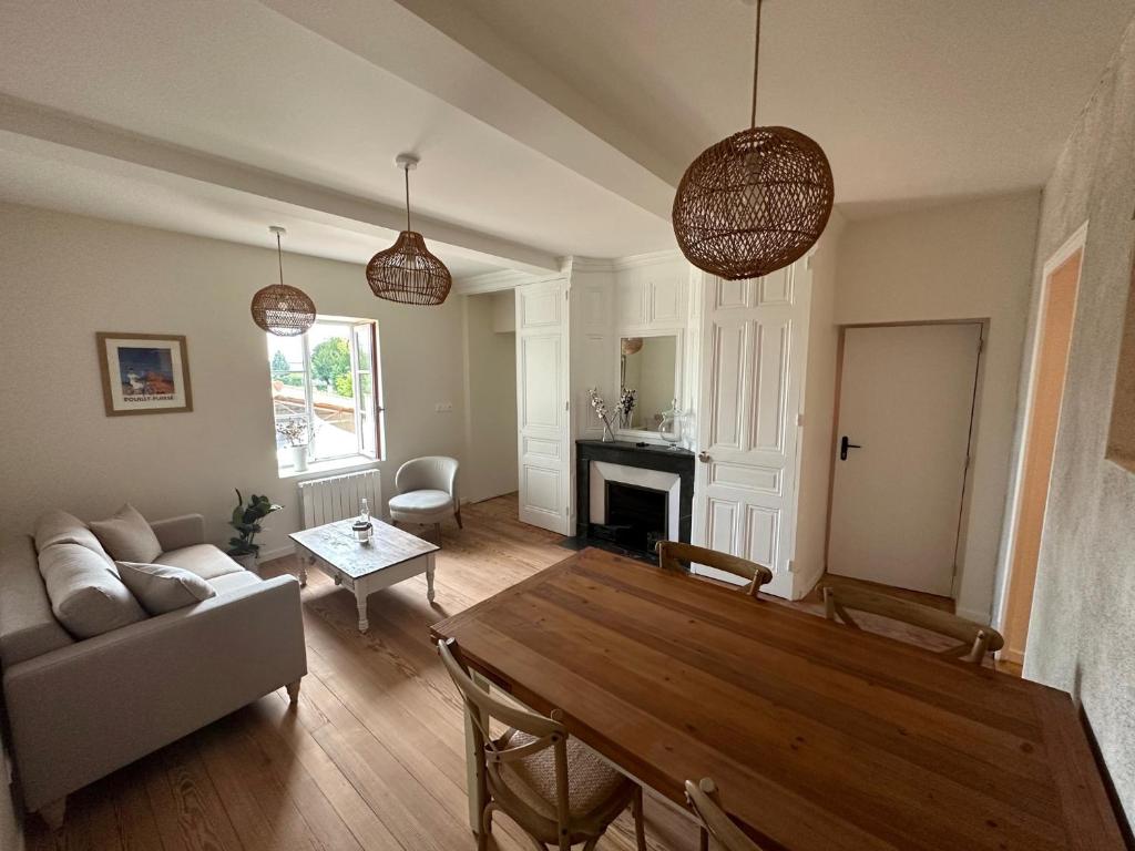 a living room with a table and a couch at La maison du village in Romanèche-Thorins