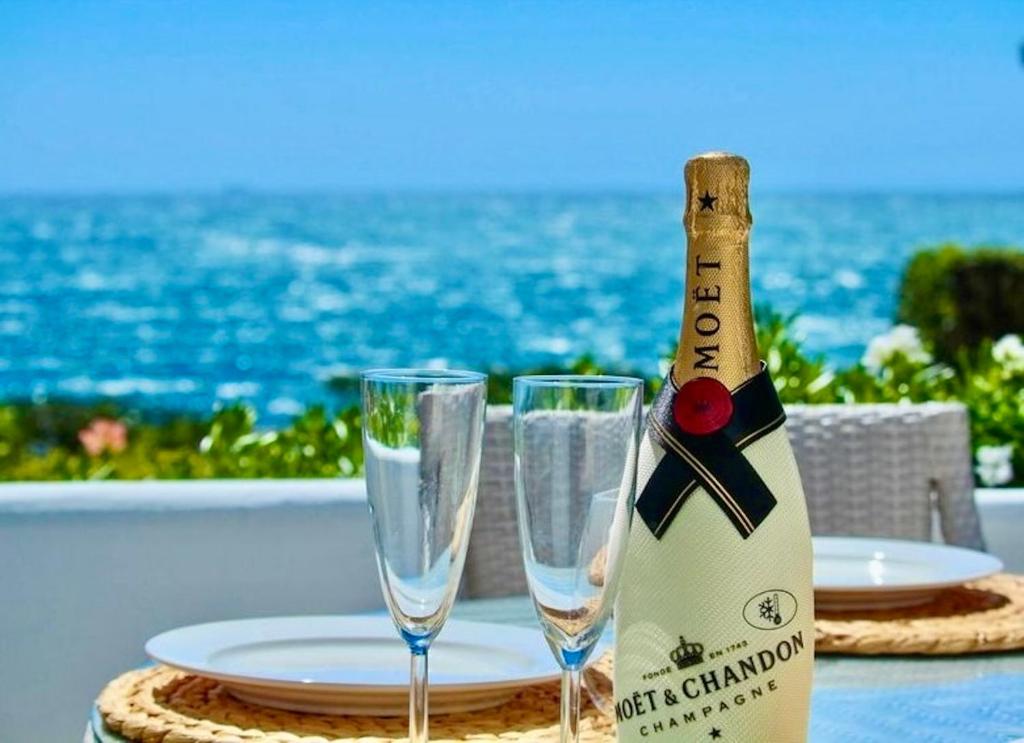 a bottle of champagne sitting on a table with two glasses at Algaida, beach apartment in Mijas Costa