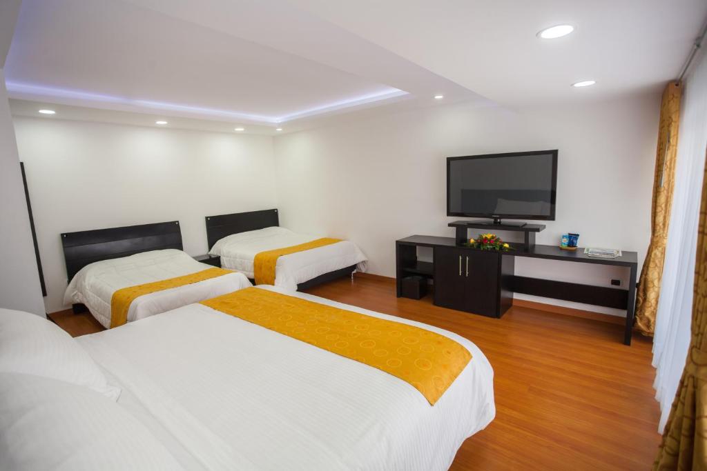 een hotelkamer met 2 bedden en een flatscreen-tv bij Hostal Habitaciones de la 39 in Pasto
