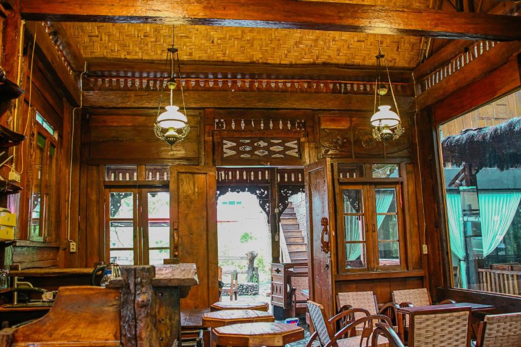 um quarto com paredes e janelas de madeira, uma mesa e cadeiras em Omah kayu bromo em Ngadisari
