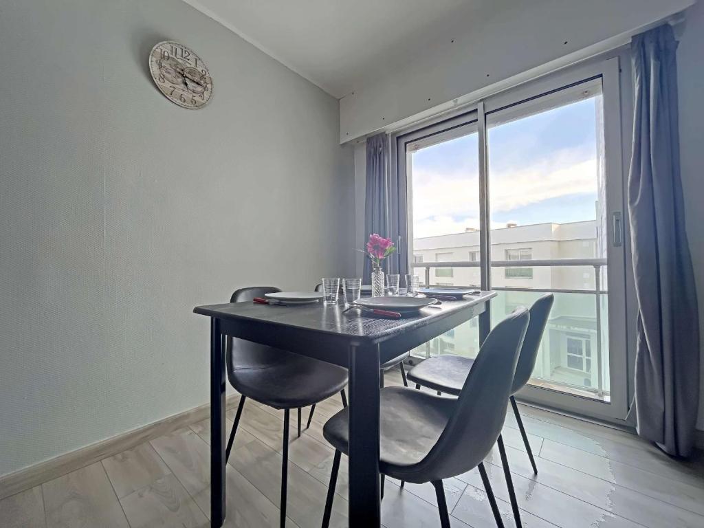 une table de salle à manger avec des chaises et une grande fenêtre dans l'établissement Studio 23m² avec Parking Privé, Ascenseur, Proche Mer - Berck - FR-1-646-19, à Berck-sur-Mer