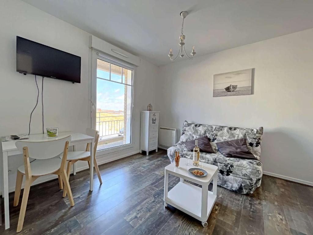salon ze stołem i kanapą w obiekcie Studio Pieds dans l'Eau, Moderne et Équipé - Rez-de-Chaussée - FR-1-646-25 w mieście Berck-sur-Mer