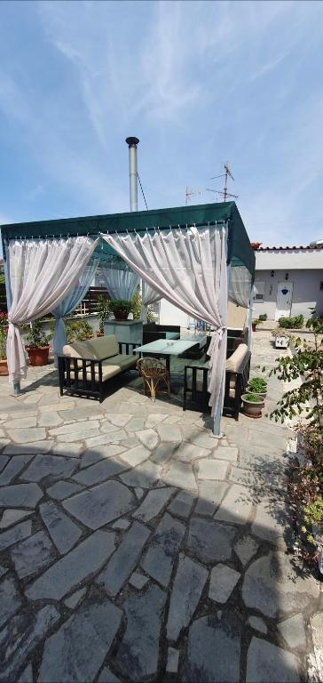 a pavilion with a table and benches on a patio at Nikol studio 2 in Kallithea Halkidikis