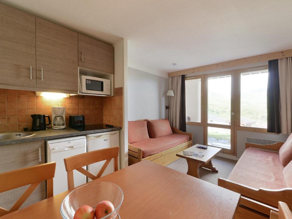 une cuisine et un salon avec une table et des chaises dans l'établissement Appartement cosy, accès direct pistes, 5 pers, Belle Plagne - FR-1-181-2386, à La Plagne Tarentaise