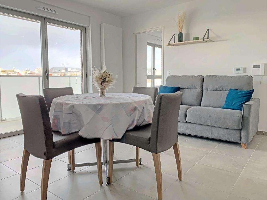una sala da pranzo con tavolo e divano di Appartement Berck-Plage, 2 pièces, 4 personnes - FR-1-646-36 a Berck-sur-Mer