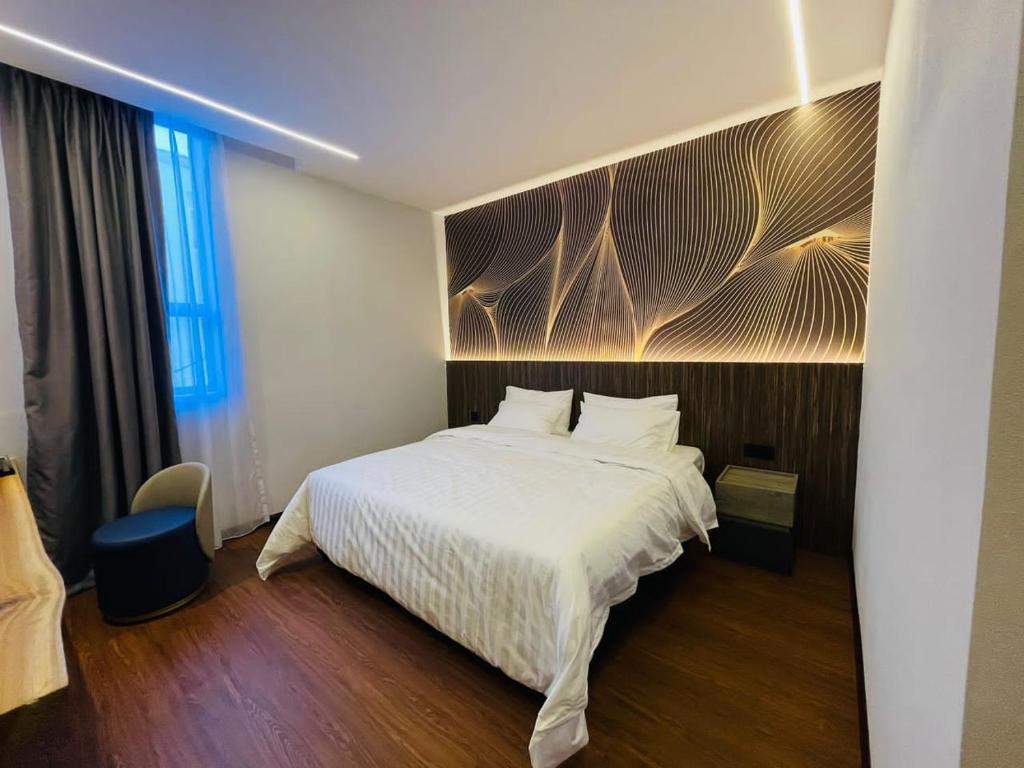um quarto com uma cama grande e uma colcha branca em Cyther Stay Hotel em Tawau
