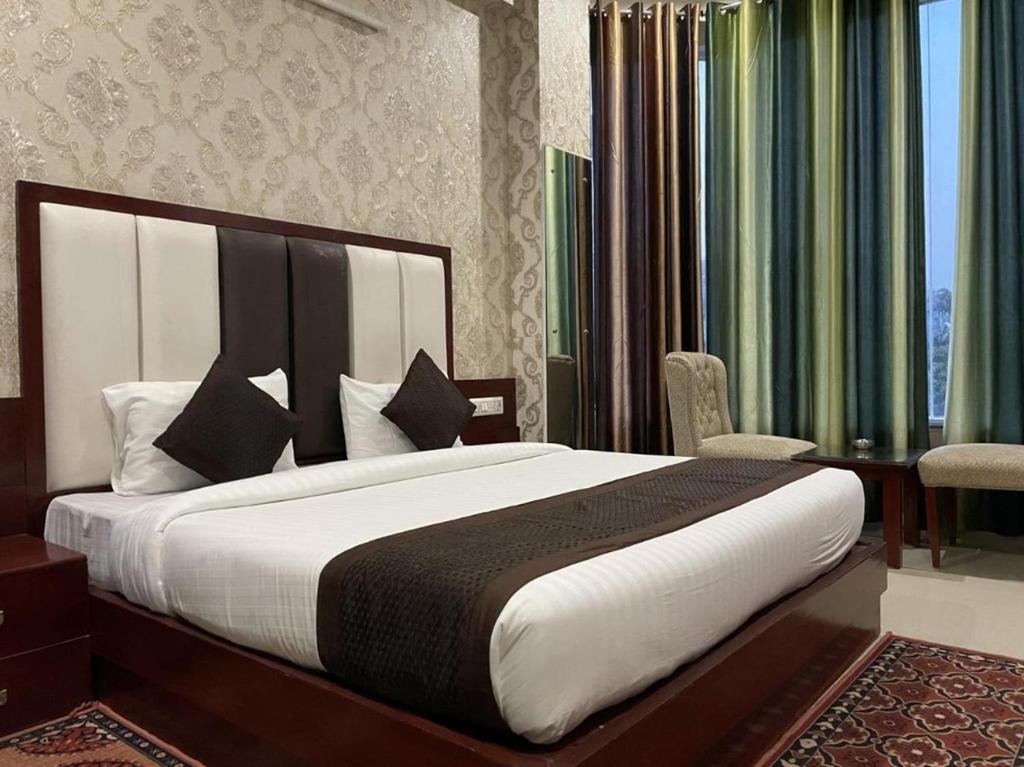 Hotel Mannat International at Paschim Vihar tesisinde bir odada yatak veya yataklar