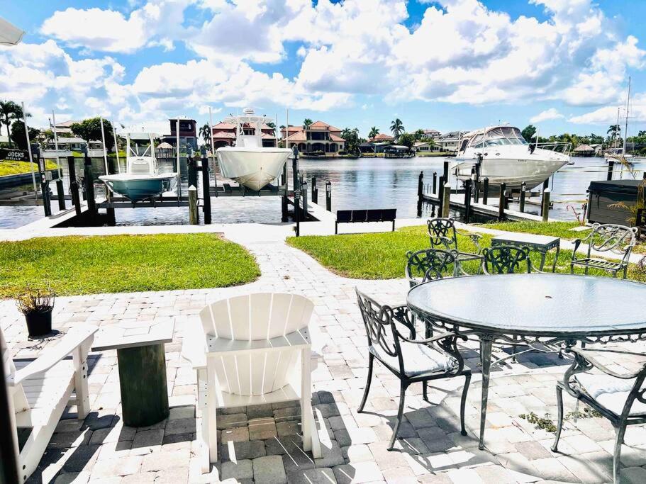 a patio with a table and chairs next to the water at Cozy 2 bedrooms home by the water in Cape Coral