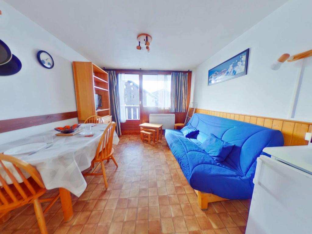 Appartement Les Saisies, 2 pièces, 5 personnes - FR-1-594-92 في هاوتيلوس: غرفة معيشة مع أريكة زرقاء وطاولة