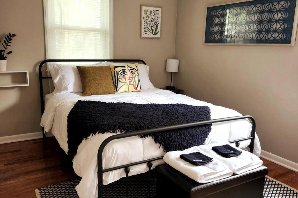 a bedroom with a black and white bed with towels on it at Cozy house near Lake Erie, 10 minutes to Downtown. in Cleveland