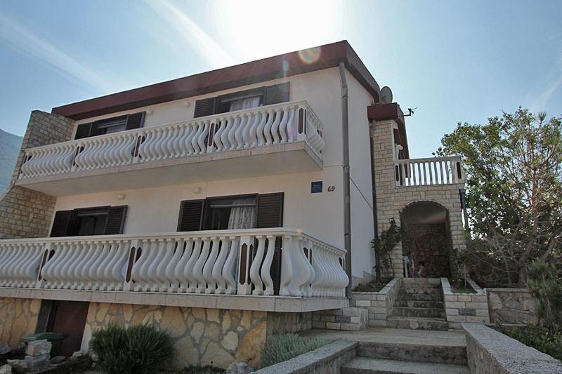 a large house with a balcony on top of it at Apartment Aida in Karlobag